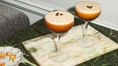Espresso Martini made with Absolut Vodka in a martini glass garnished with 3 coffee beans.