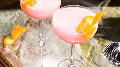 Absolut Cosmo cocktail made with Absolut Citron lemon-flavored vodka in a martini glass garnished with an orange twist