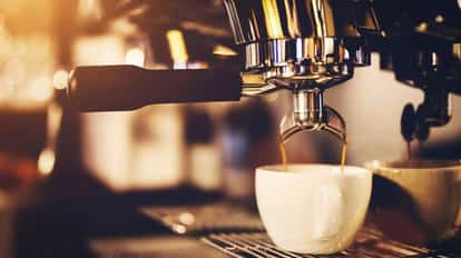 Coffee machine pouring espresso into a white cup.