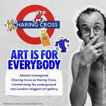 Keith Haring looking at London underground sign saying Haring Cross with Absolut Haring bottle on it.