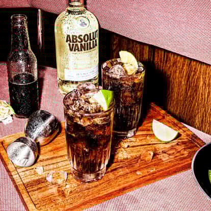 Classic Absolut Vanilia Cola next to a bottle of Absolut Vanilia vodka