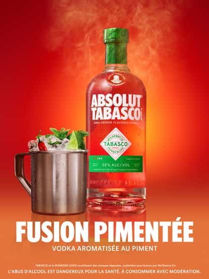 Publicité rouge montrant la vodka ABSOLUT® TABASCO™ au piment, accompagnée d’un cocktail spicy mule, avec le slogan « Fusion pimentée ».