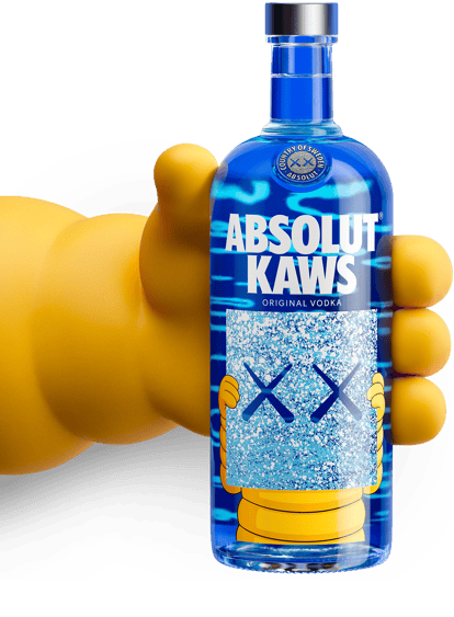 Absolut KAWS artist edition vodka bottle in a hand against a blue background.