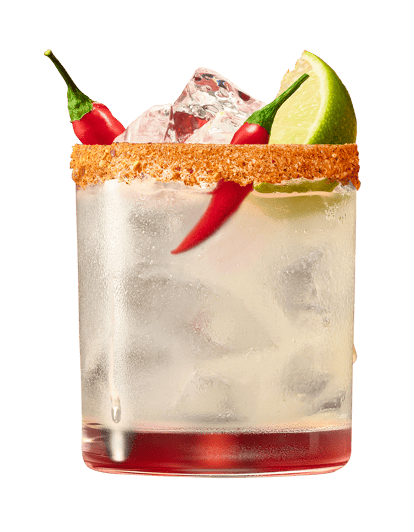 Close-up of a Spicy Vodkarita cocktail in a rocks glass with a Cajun spice rim, ice, red chili peppers, and a lime wedge