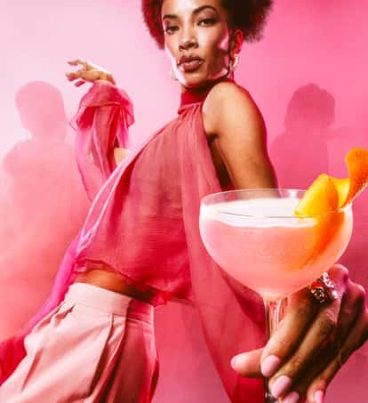 a woman in pink holds an Absolut Cosmo