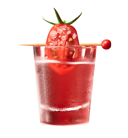 Close-up of a red Bloody Mary shot in a clear glass, topped with a salted cherry tomato skewer