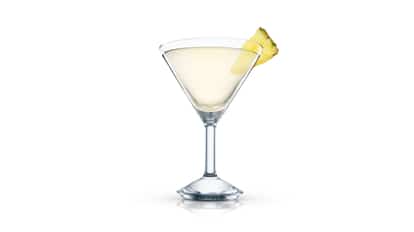 Absolut Peppar Pineapple Martini served in a martini glass with pineapple wedge on rim on white background