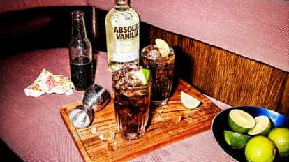 Classic Absolut Vanilia Cola next to a bottle of Absolut Vanilia vodka