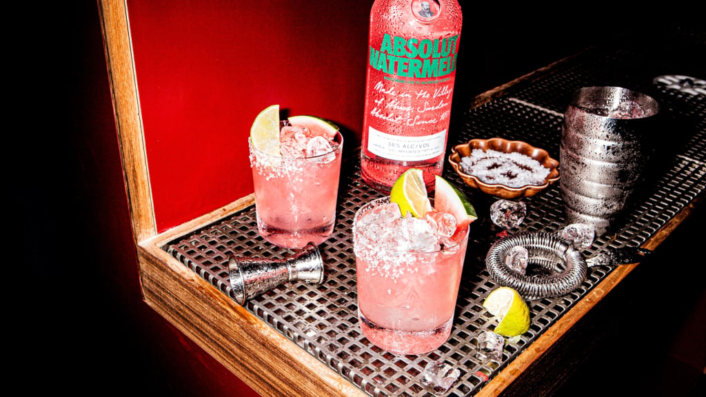 Absolut Watermelon Vodkarita in a rocks glass next to a bottle of Absolut Watermelon.